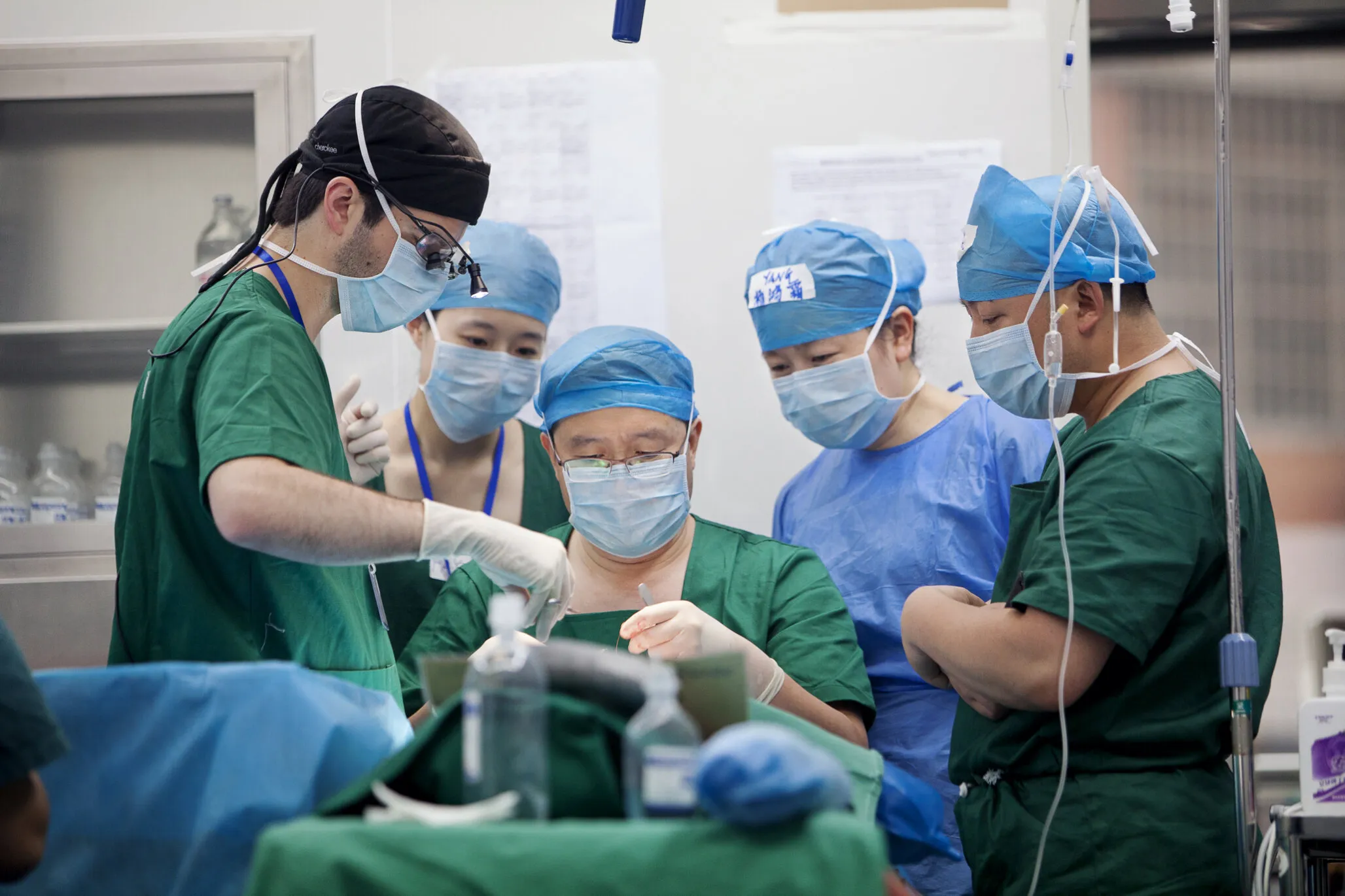 Volunteer plastic surgeon Dr. Shu Maoguo of China, center, and plastic surgeon observer Dr. Brad Gandolfi of the U.S., left, perform surgery on 13-year-old Shijun.