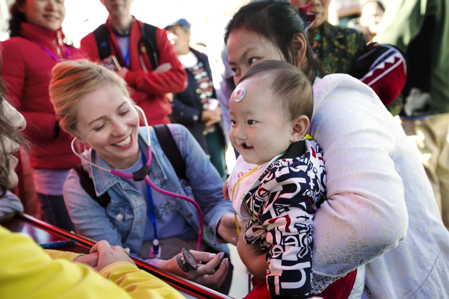Volunteer pediatrician Dr. Elena Belonogova from Russia examines Yi Miang during screening day