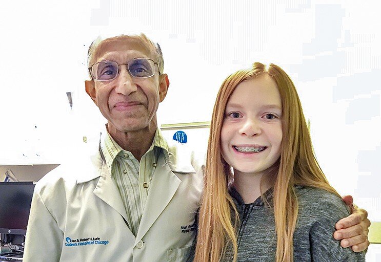 Eleven-year-old Elizabeth Alberti smiles next to her surgeon and Operation Smile volunteer Dr. Arun Gosain