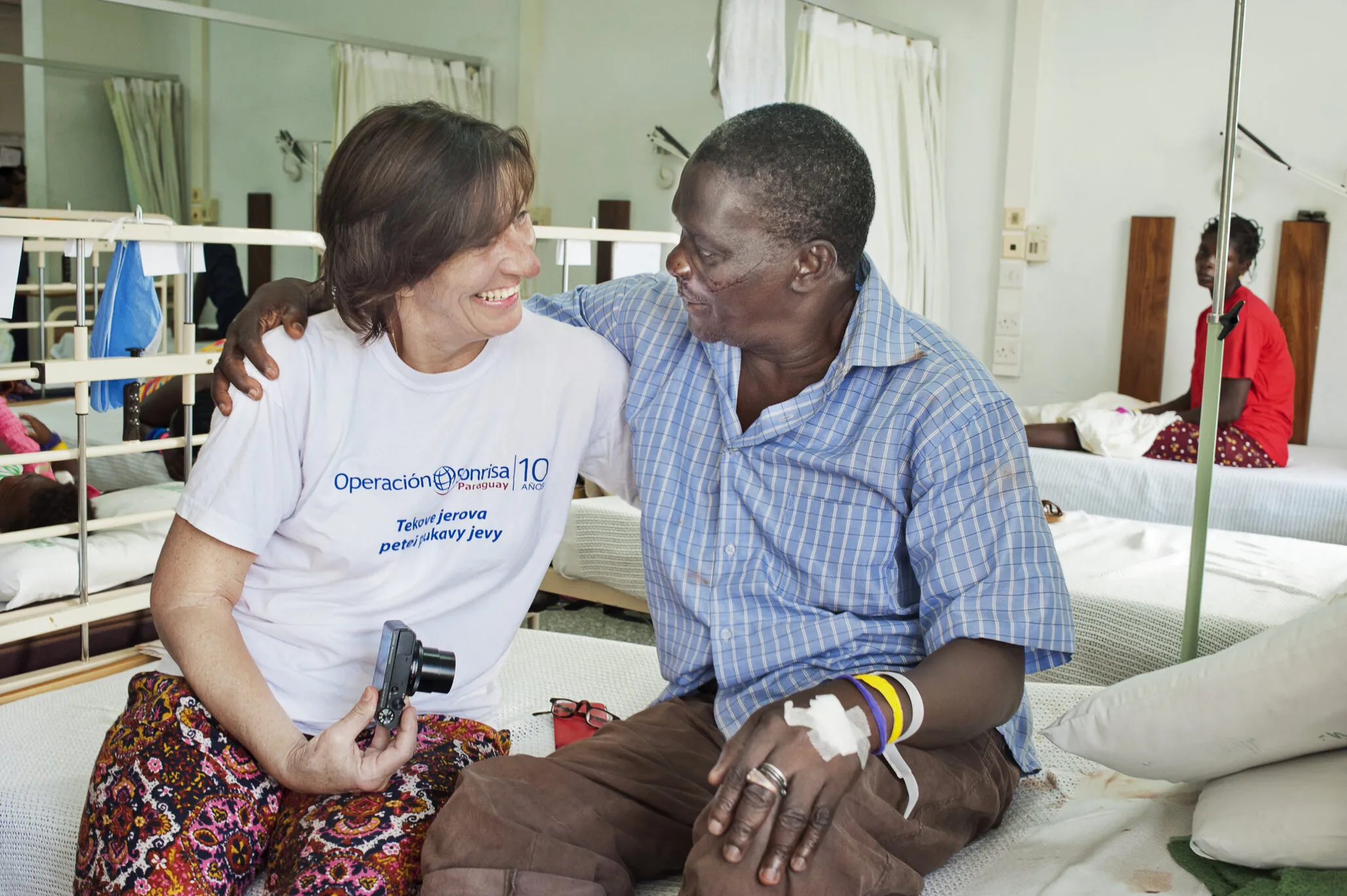 In the recovery room after his cleft lip surgery, Iddrisah sits beside volunteer cleft surgeon Dr. Ulrike Lamle of Germany during a 2015 Operation Smile Ghana surgical program.