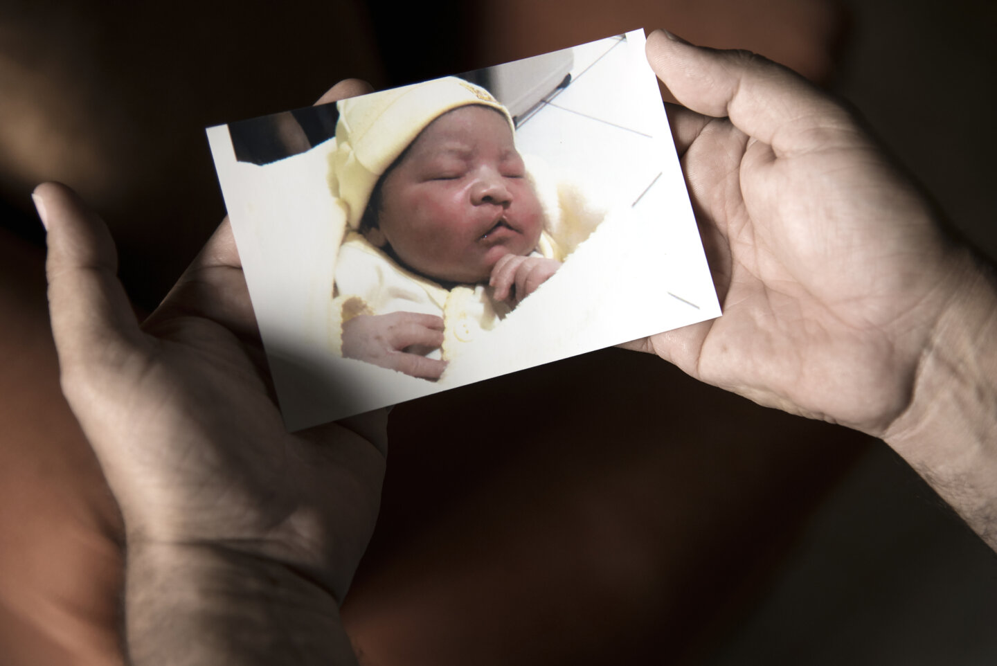 Alex holds a baby photo of his son Cesar in his home in Juticalpa, Honduras March 29, 2016.