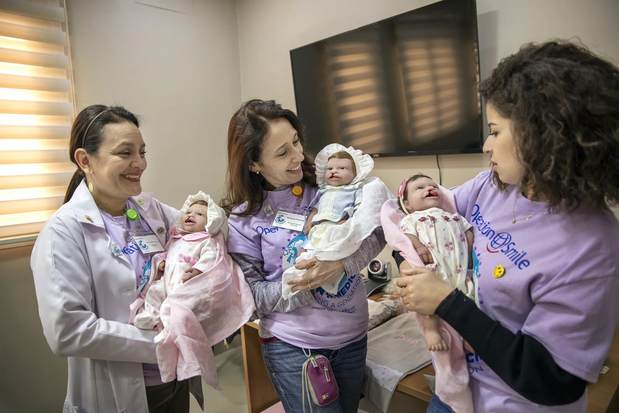 Volunteer dentists Drs. Vilma Arteaga of Guatemala, left, Teresita Pannaci of Venezuela, center, and Soukaina Dahou of Morocco each hold a dental simulation doll.