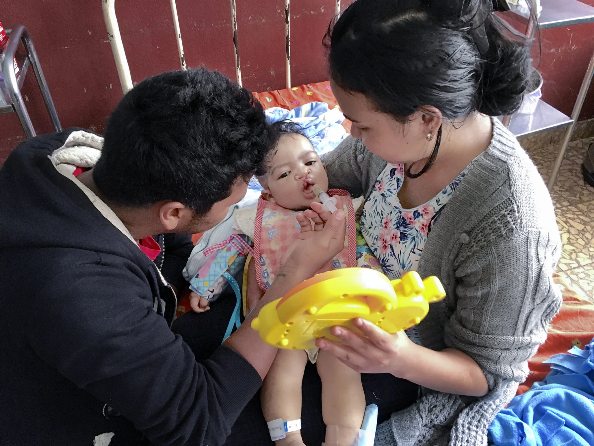 Tsifoina is held by his parents after surgery.