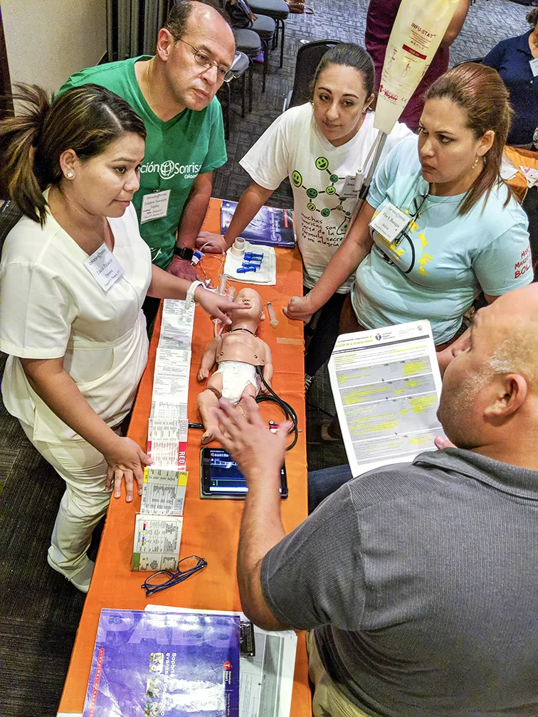 Nurses and anesthesiologists from Panama, Colombia and Bolivia listen to a case scenario presented by Paraguayan pediatrician Dr. Gustavo Zaracho, bottom right, during a PALS course.