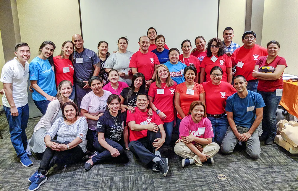 Newly-credentialed AHA instructors, who just taught their first BLS course, pose for a photo with their trainees.