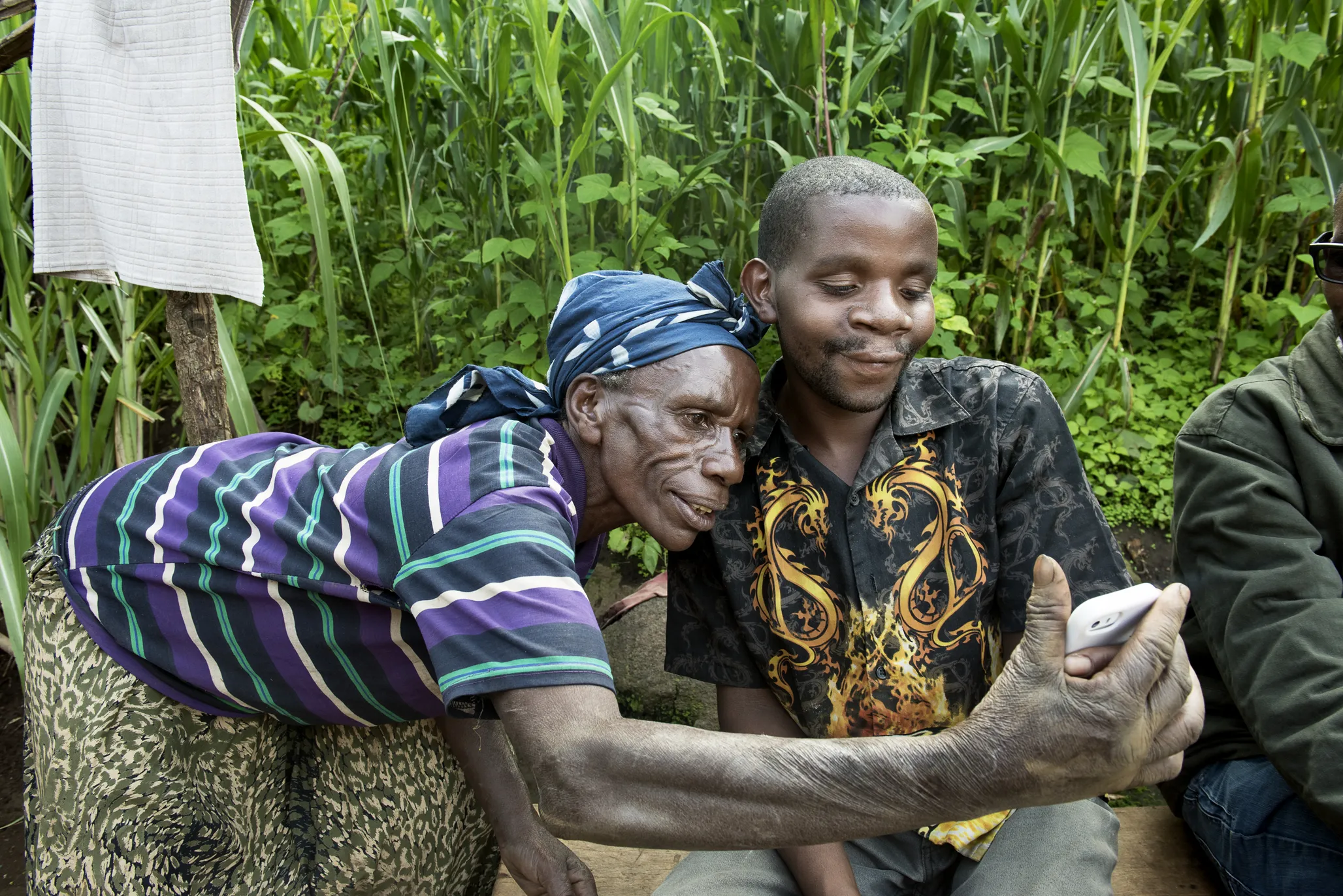 Enok and his mother, Nyiramafahasheri, share a look at a phone.