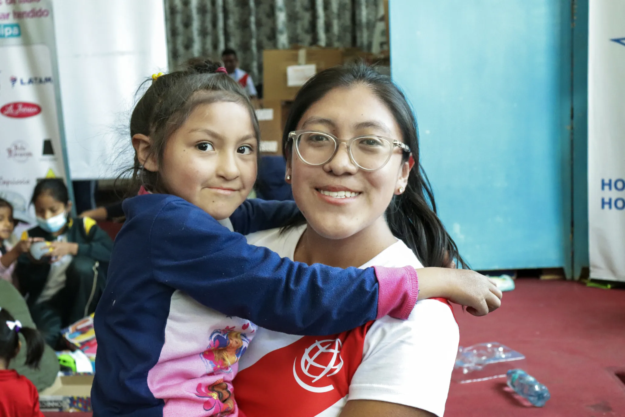 Angeles holds a patient and smiles for the camera during a surgical program in Peru.