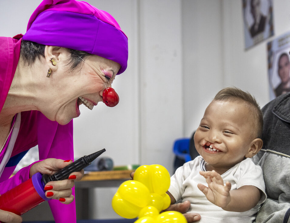Ihan laughs while playing with a member of Clowns without Borders.