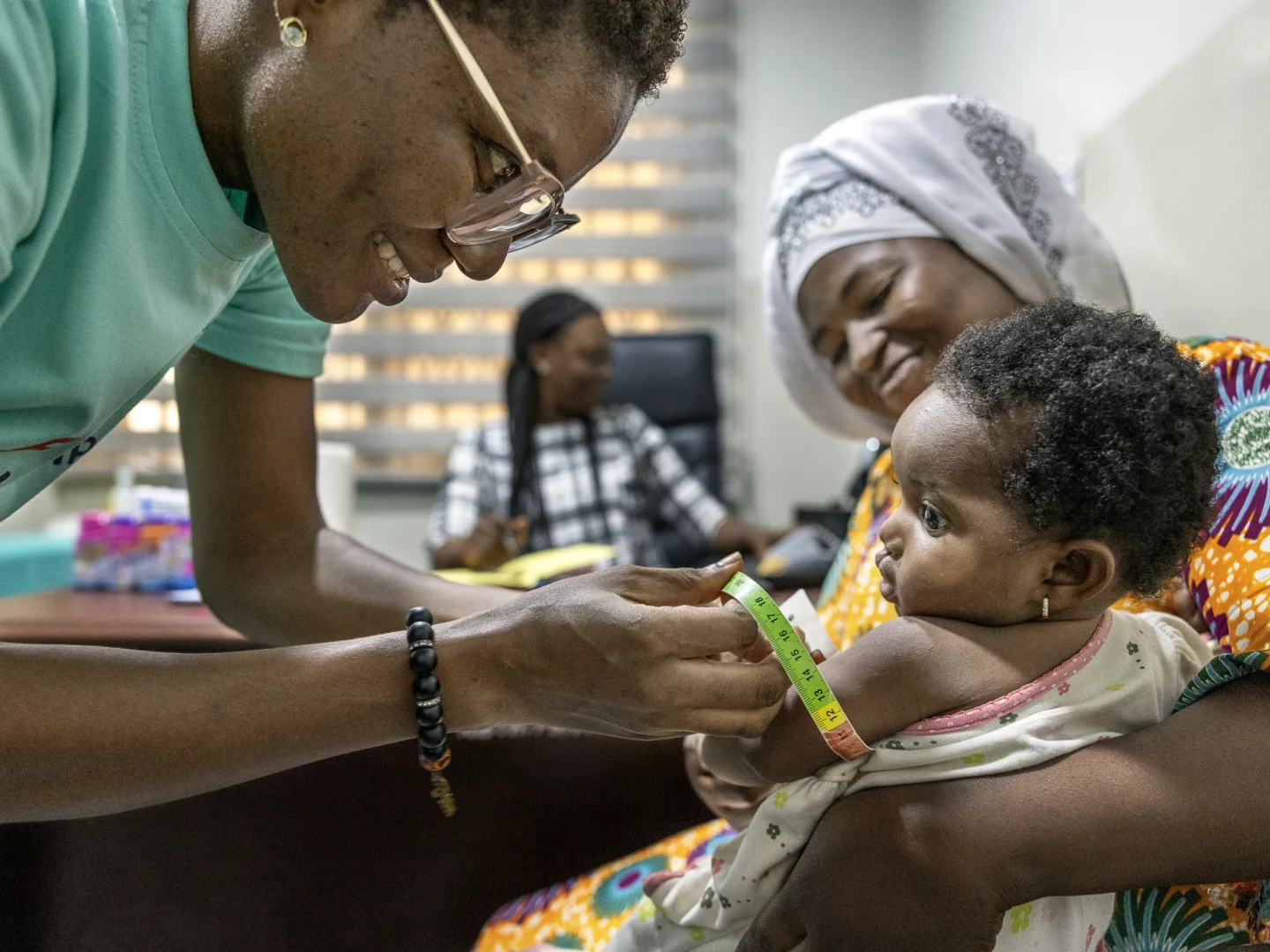 Alimatu holds Farida while a volunteer nutritionist from Ghana performs an assessment to determine if she is able to receive surgery.