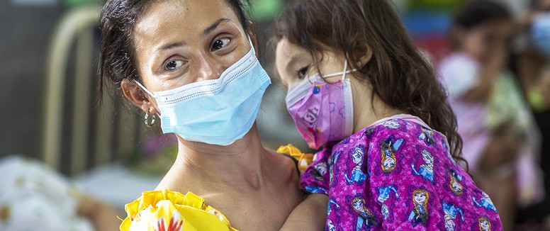 Ana, holds her daughter, Zoe, wearing masks in the pre-operative ward during an Operation Smile Honduras surgical program. 