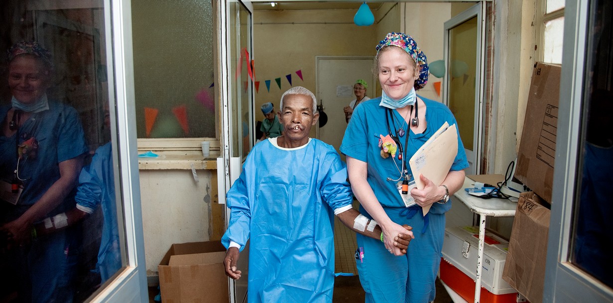 Alfred walks hand-in-hand into the operating room with post-anesthesia care unit physician Isabelle Simoneau of the U.S. during a 2018 Operation Smile surgical program in Antsirabe, Madagascar.