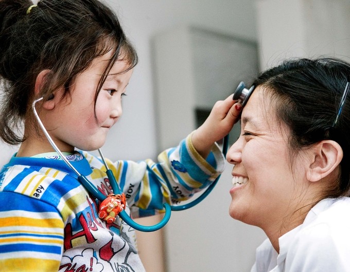 Heather Yang of Canada with a little girl in Pre-Op before her palate surgery playing with a stethoscope.