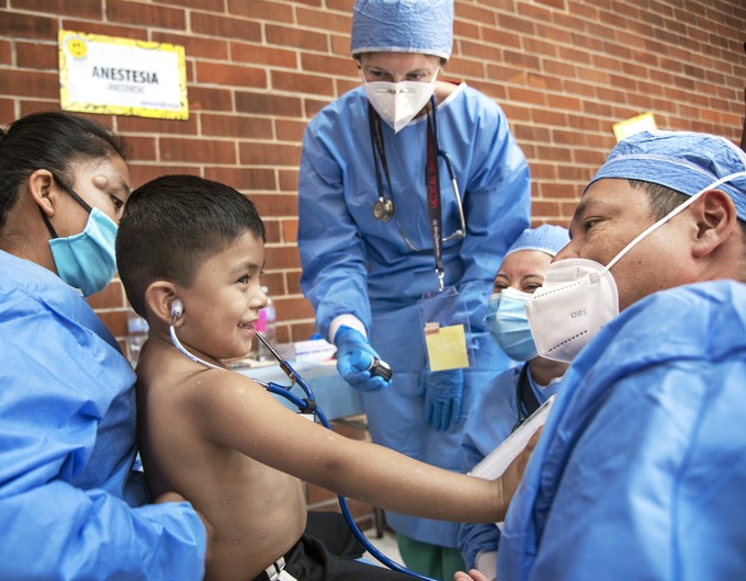 A child listens to the heartbeat of anesthesiologist Emilio Peralta, right, as Pediatrician Samantha Jackson-Dilts, center, and Anesthesiologist Resident Silvia Ramos of Guatemala look on during screening at Operation Smile’s medical program in Guatemala City, Guatemala.