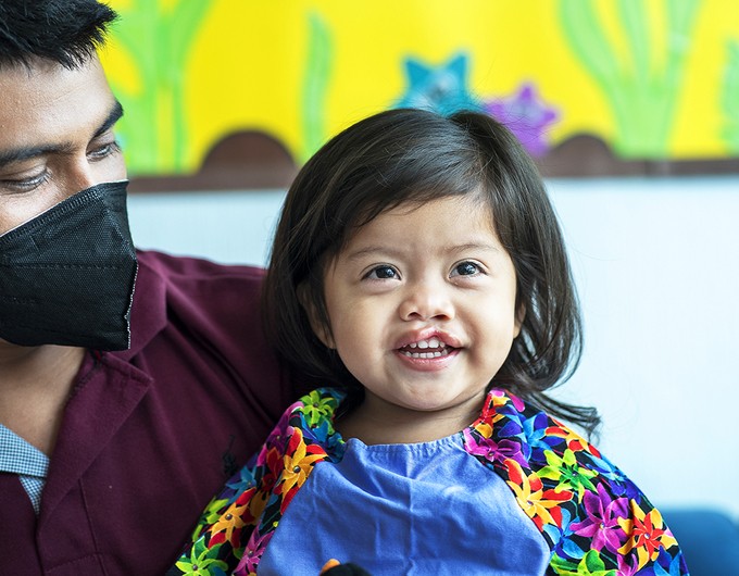 Lia is dressed in her hospital gown as she sits next to her father, Gerardo, during Operation Smile’s surgical program in Guatemala City. Photo: Rohanna Mertens.