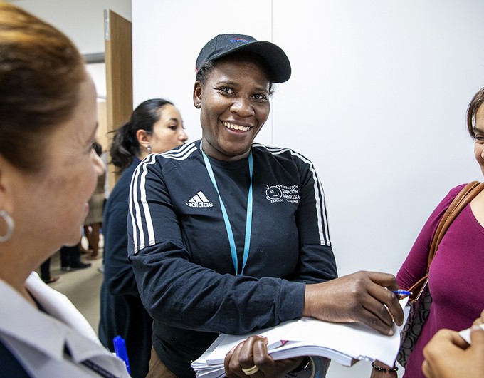 Wearing a black Adidas jacket, clinical coordinator Homaire Caicedo of Ecuador speaks with families during screening at a 2019 surgical program in Quito, Ecuador. 