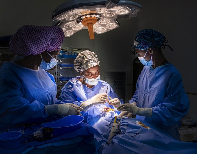 In a Kamuzu Central Hospital operating room, cleft surgeon Dr. Wone Banda, center, with surgical scrub personnel Lucy Dodoli and pre- and post-operative nurse Grace Chirwa perform surgery during the 2022 Malawi Women in Medicine program. 