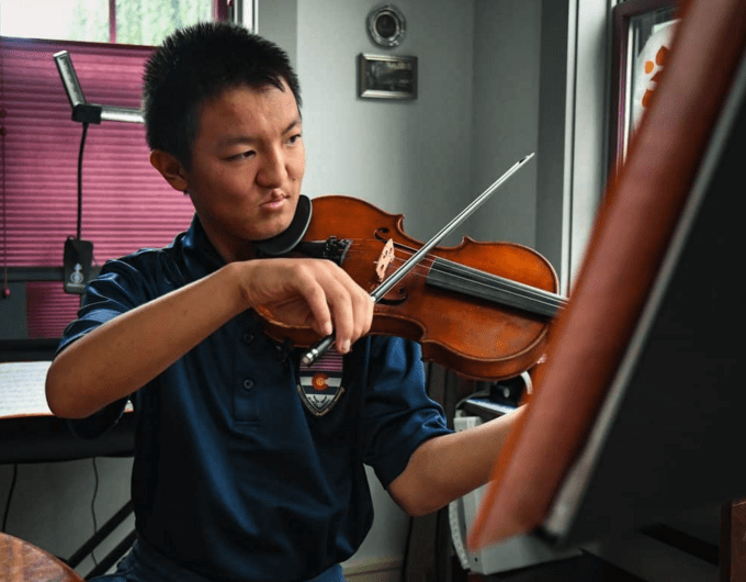 Fifteen-year-old Willy Sikora plays the violin. 