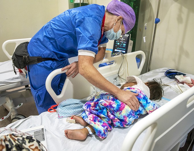 During the 2022 Women in Medicine program in the Philippines, volunteer nurse Carola Noren of Sweden looks in on a patient following their cleft surgery. 