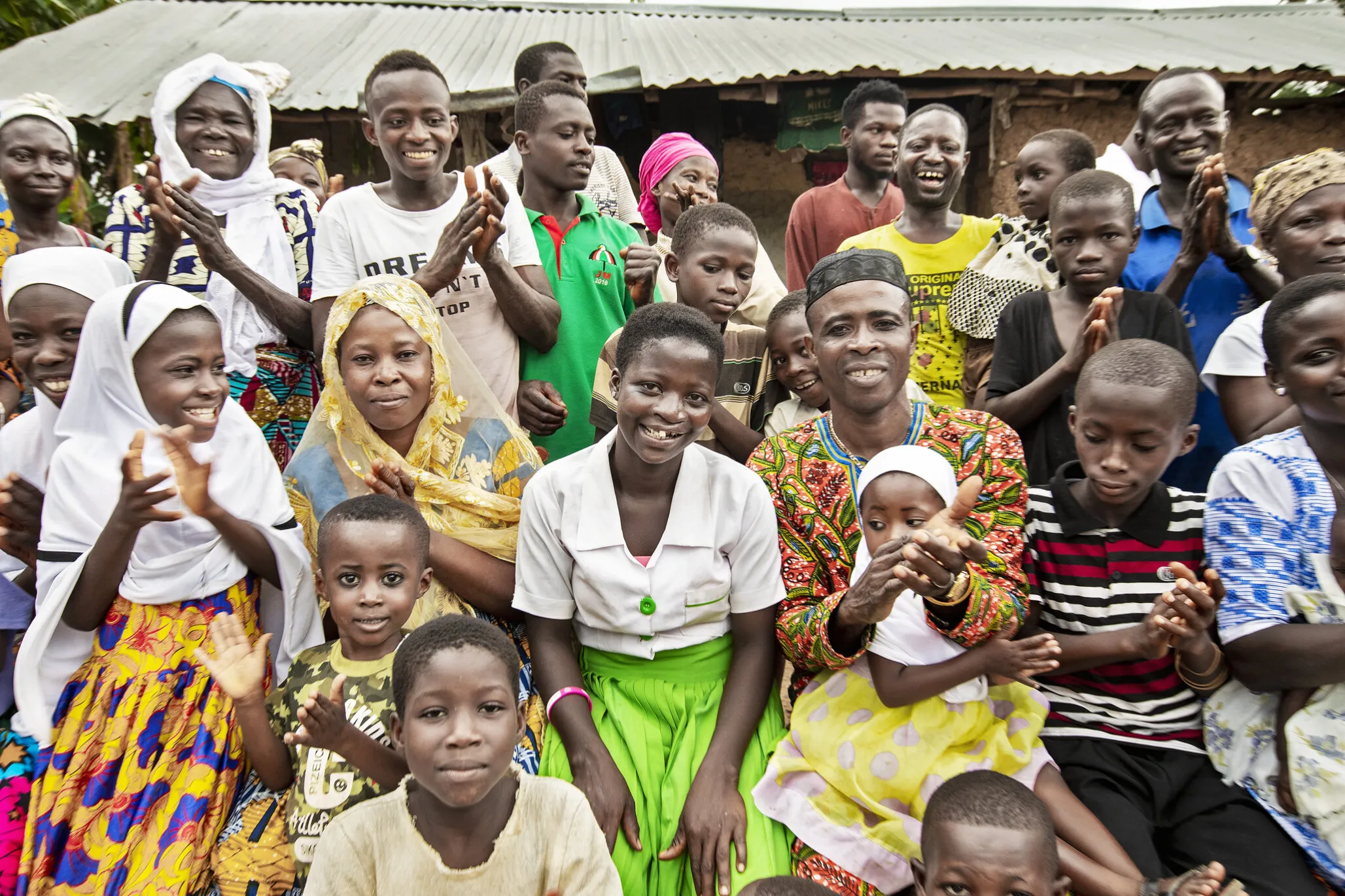 Faustina poses with her family and members of her community.