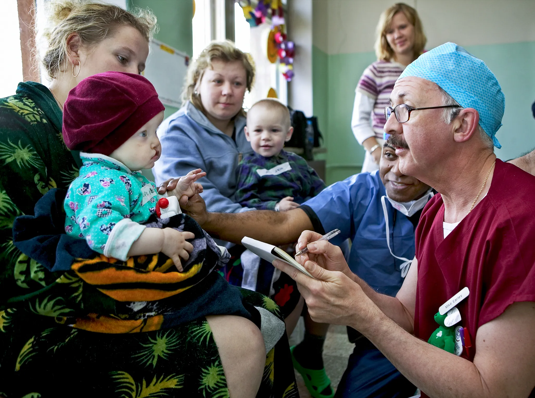 Volunteer plastic surgeon Dr. Mike Earley of Ireland shares a moment with 9-month-old Tatyana during a 2004 surgical program.