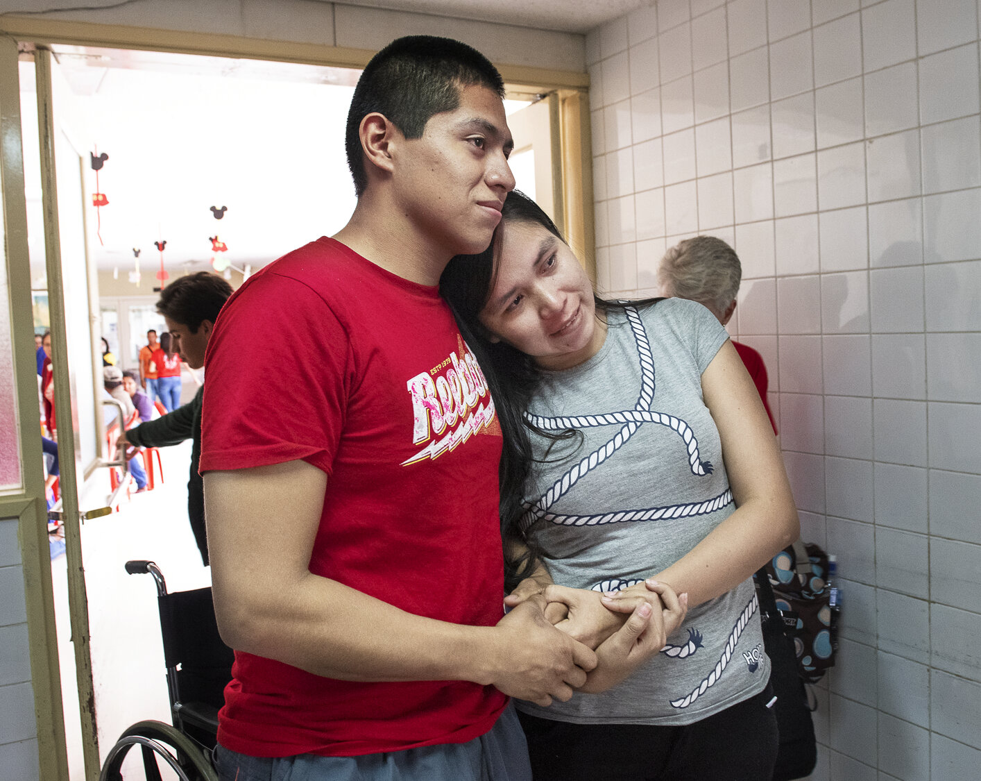 America and Felipe hold on to each other as they watch their son being taken into the operating room.