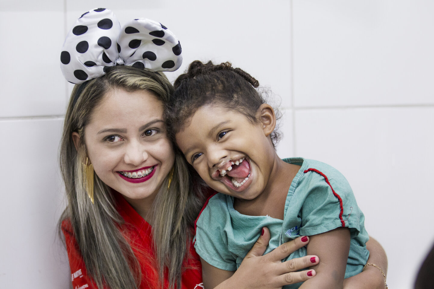 Antonia shares a big smile with 4-year-old Maria Clara during a 2016 surgical program in Fortaleza, Brazil.