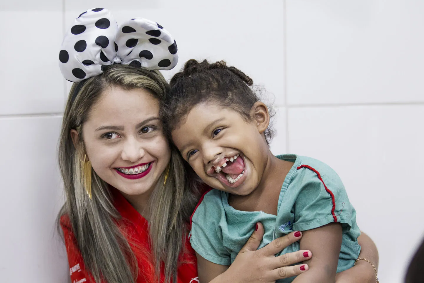 Antonia shares a big smile with 4-year-old Maria Clara during a 2016 surgical program in Fortaleza, Brazil.