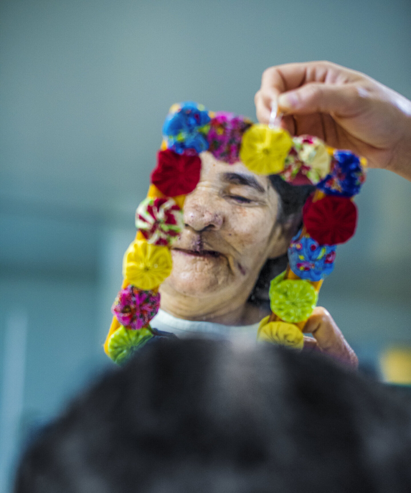 Dona Maria looks in the mirror after surgery.