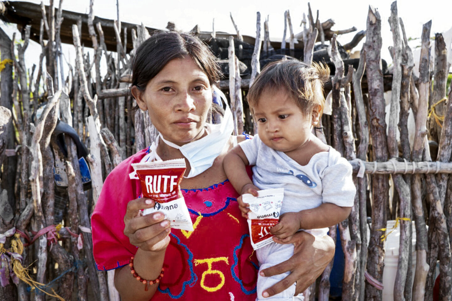 Patricia and her son, Wilmar, stand in their kitchen in La Guajira holding a package of ready-to-use therapeutic food.