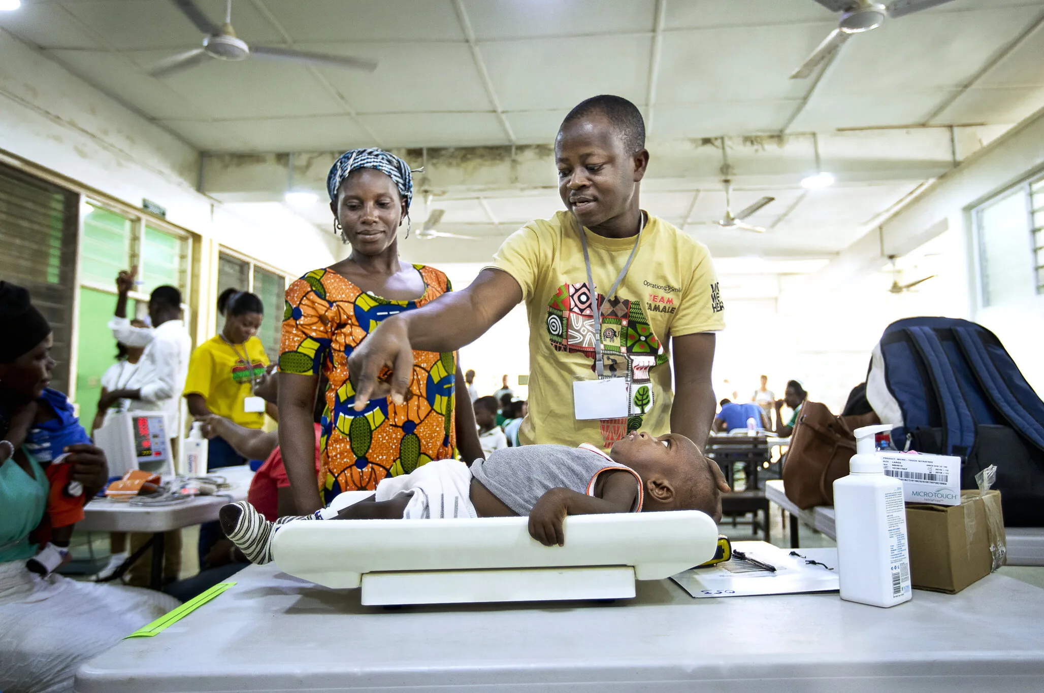 During Operation Smile Ghana’s first local surgical program, 11-month-old Moses is placed on a scale to determine his weight by recovery room nurse Michael Agbavor as his mom, Aba, observes.
