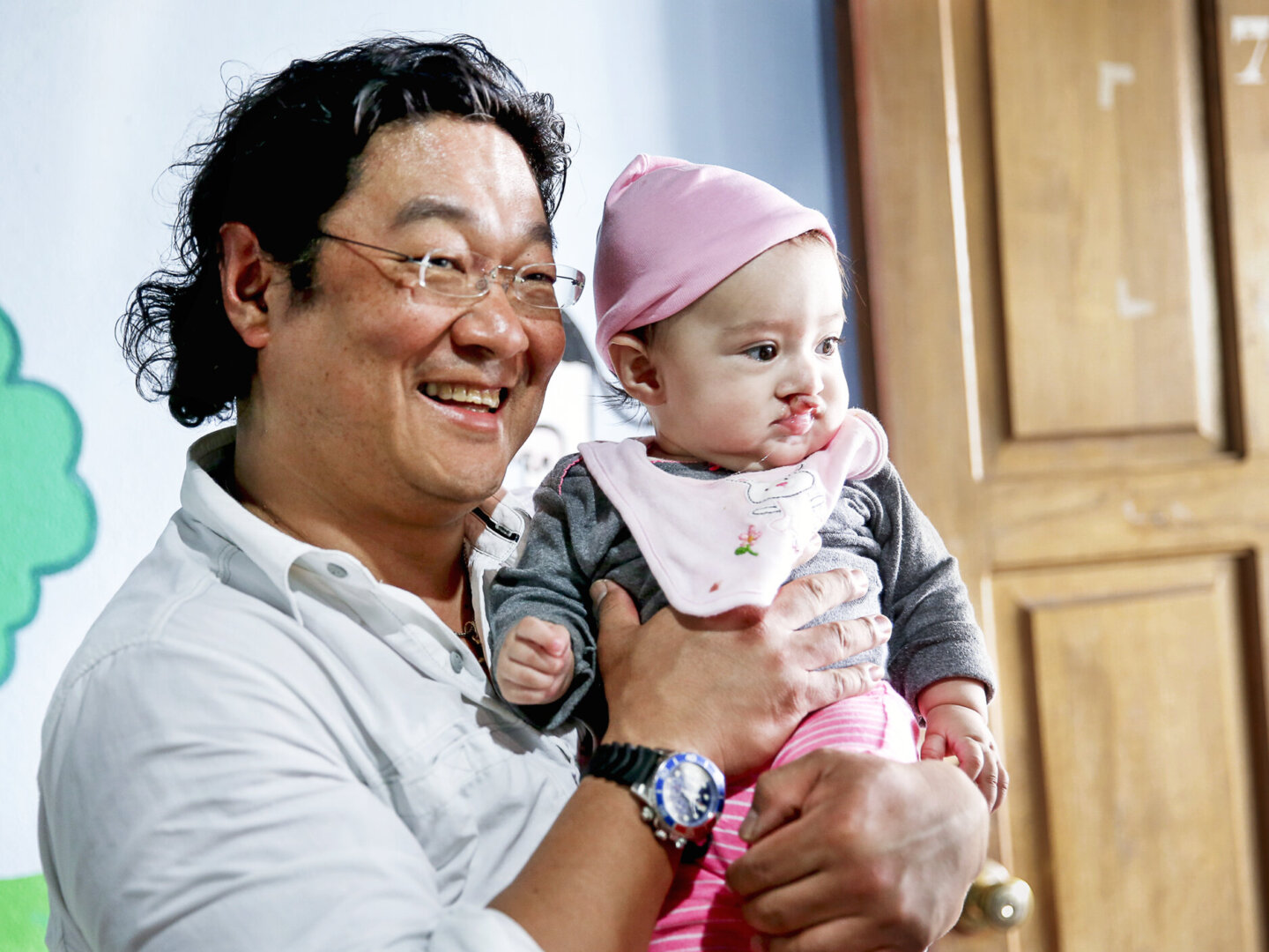 Surgeon Dan Pyo holds a patient.