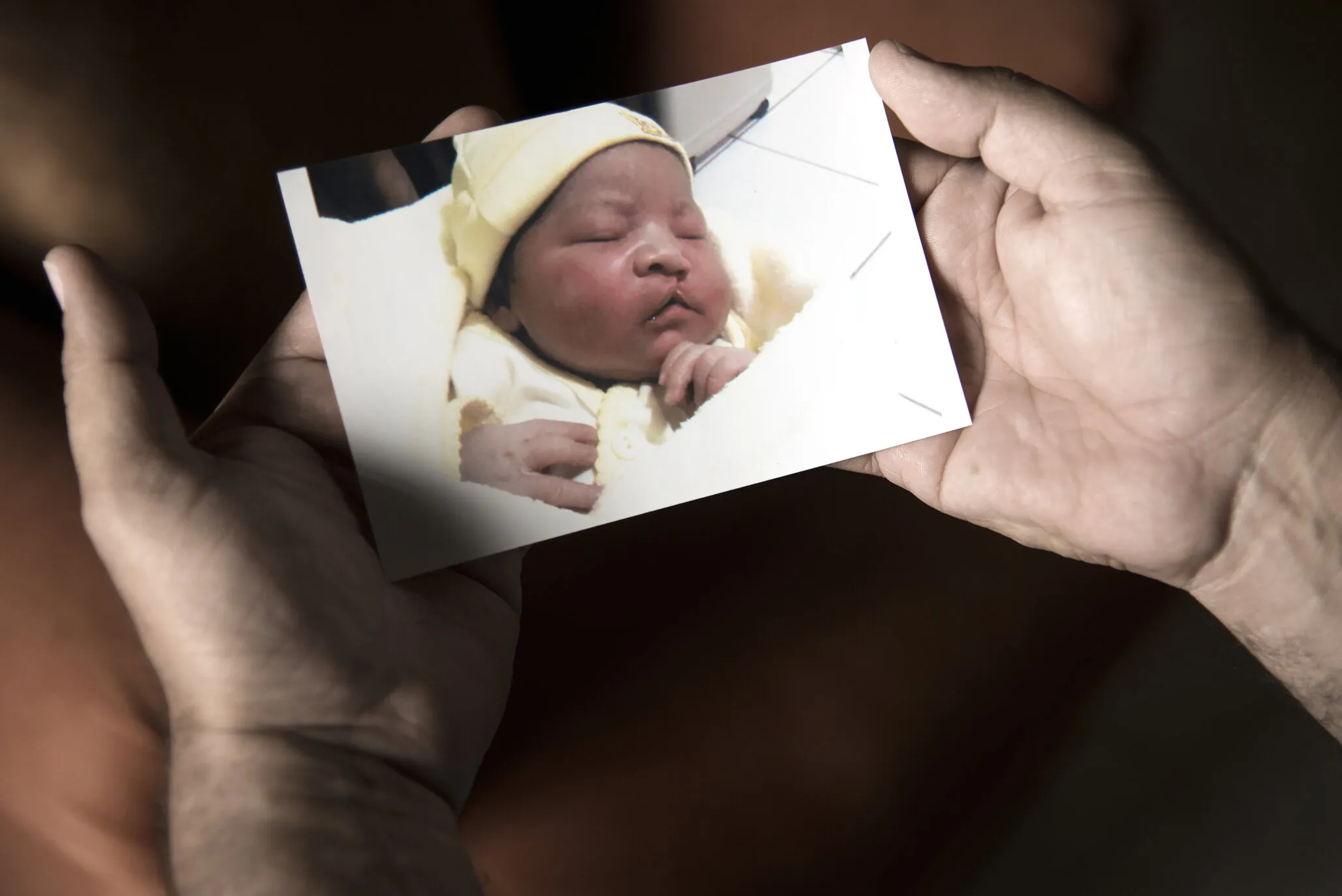 Alex holds a baby photo of his son Cesar in his home in Juticalpa, Honduras March 29, 2016.
