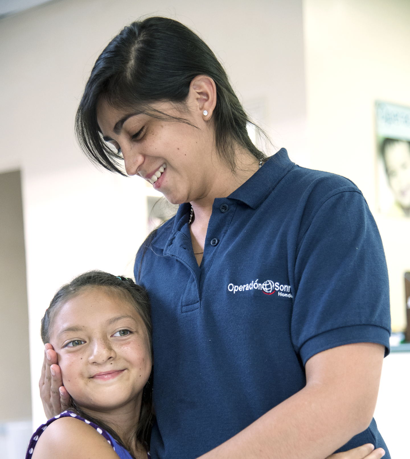 Stephany Martínez, Operation Smile Honduras Patient Coordinator, embraces Britany at one of her care center visits.