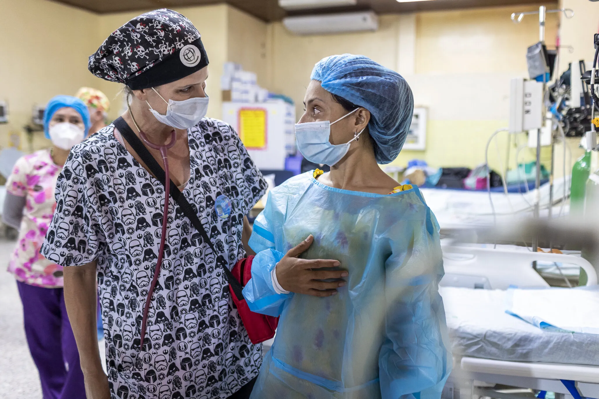Ana, Zoe's mom, speaks with a volunteer at a surgical program in Tegucigalpa, Honduras.