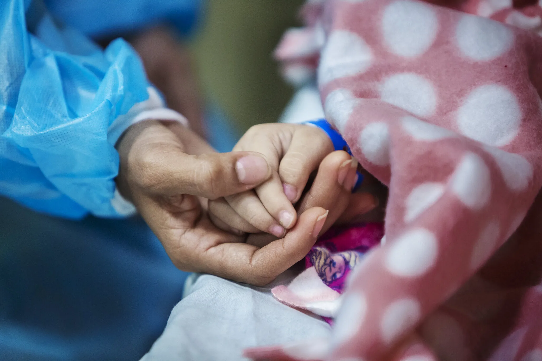 Ana holds her daughter's hand after surgery.