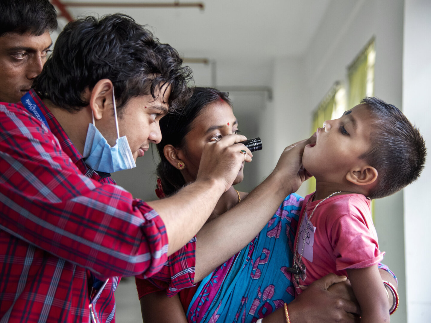 Volunteers examine Shyam during a program in Durgapur, India.