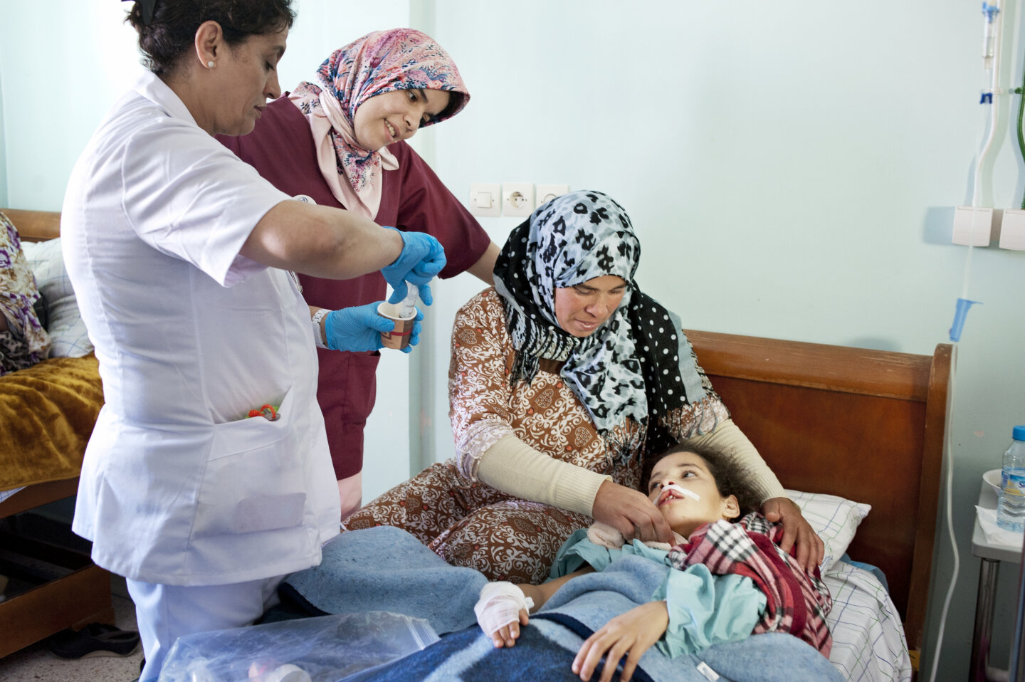 Siham's mom, Samira, holds her daughter in the recovery room after surgery.