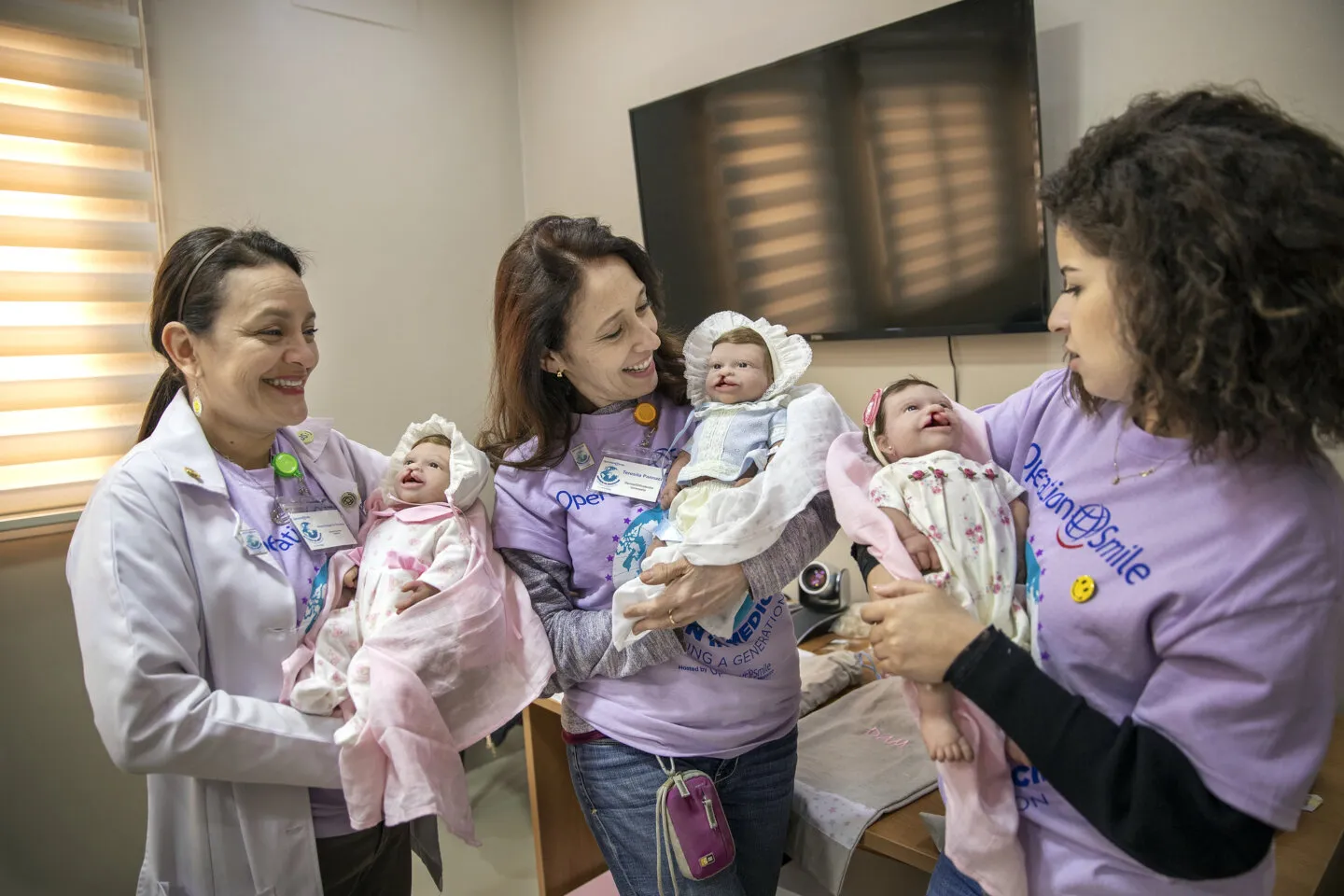 Volunteer dentists Drs. Vilma Arteaga of Guatemala, left, Teresita Pannaci of Venezuela, center, and Soukaina Dahou of Morocco each hold a dental simulation doll.