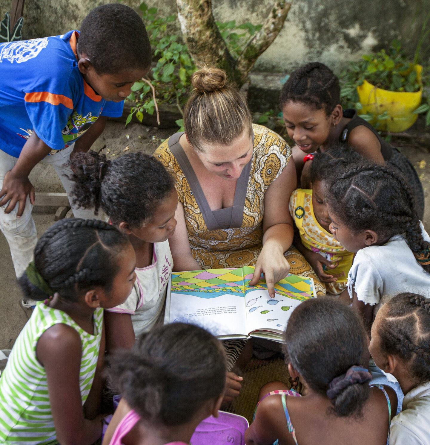 Charlotte Steppling reads to a group of children in Madagascar.