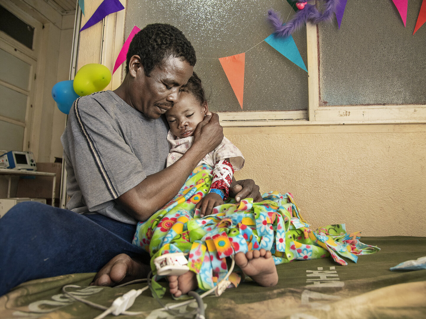 Brunel's father holds her after surgery.