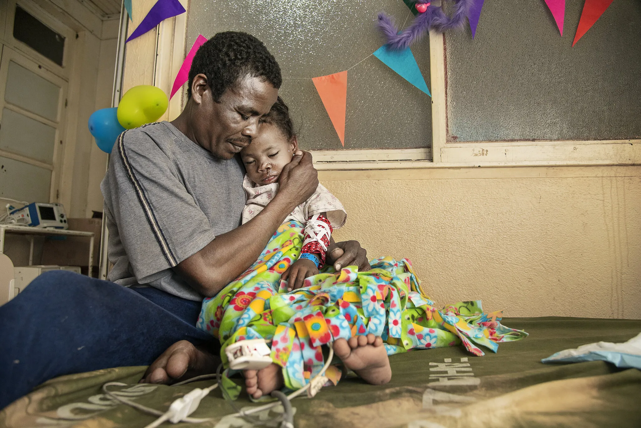 Brunel's father holds her after surgery.