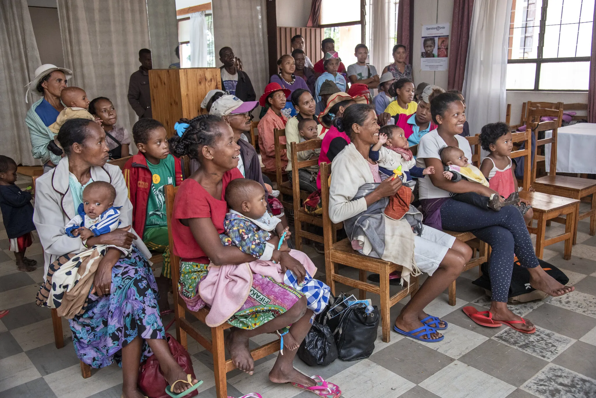 At the patient shelter, participants in the feeding program listen as Charlotte talks about the importance to food diversification, nutrition and breastfeeding techniques.
