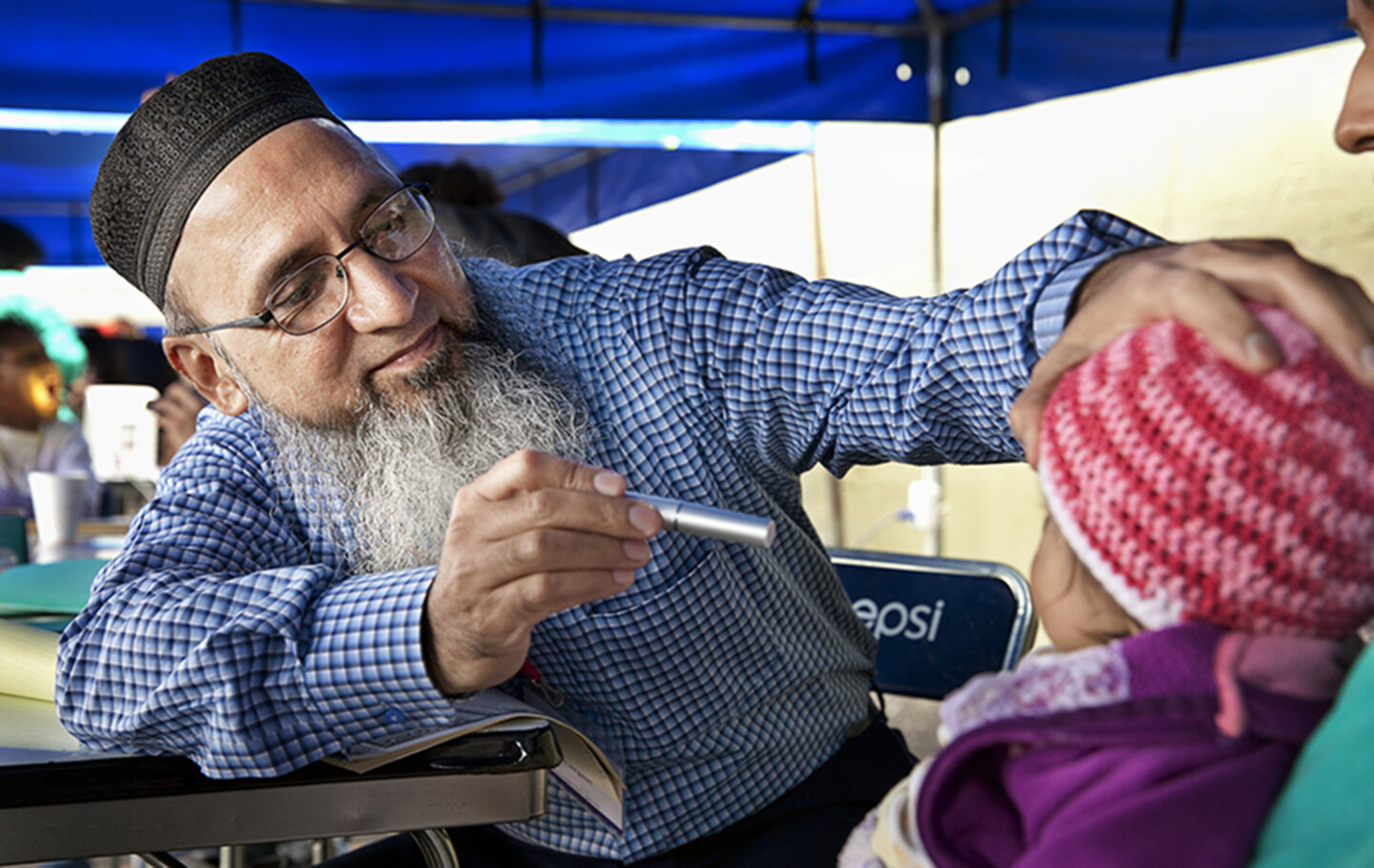 An Operation Smile volunteer examines a patient.