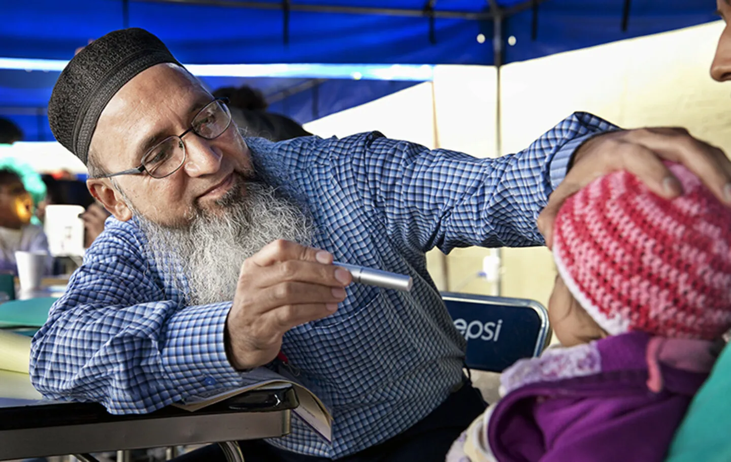 An Operation Smile volunteer examines a patient.