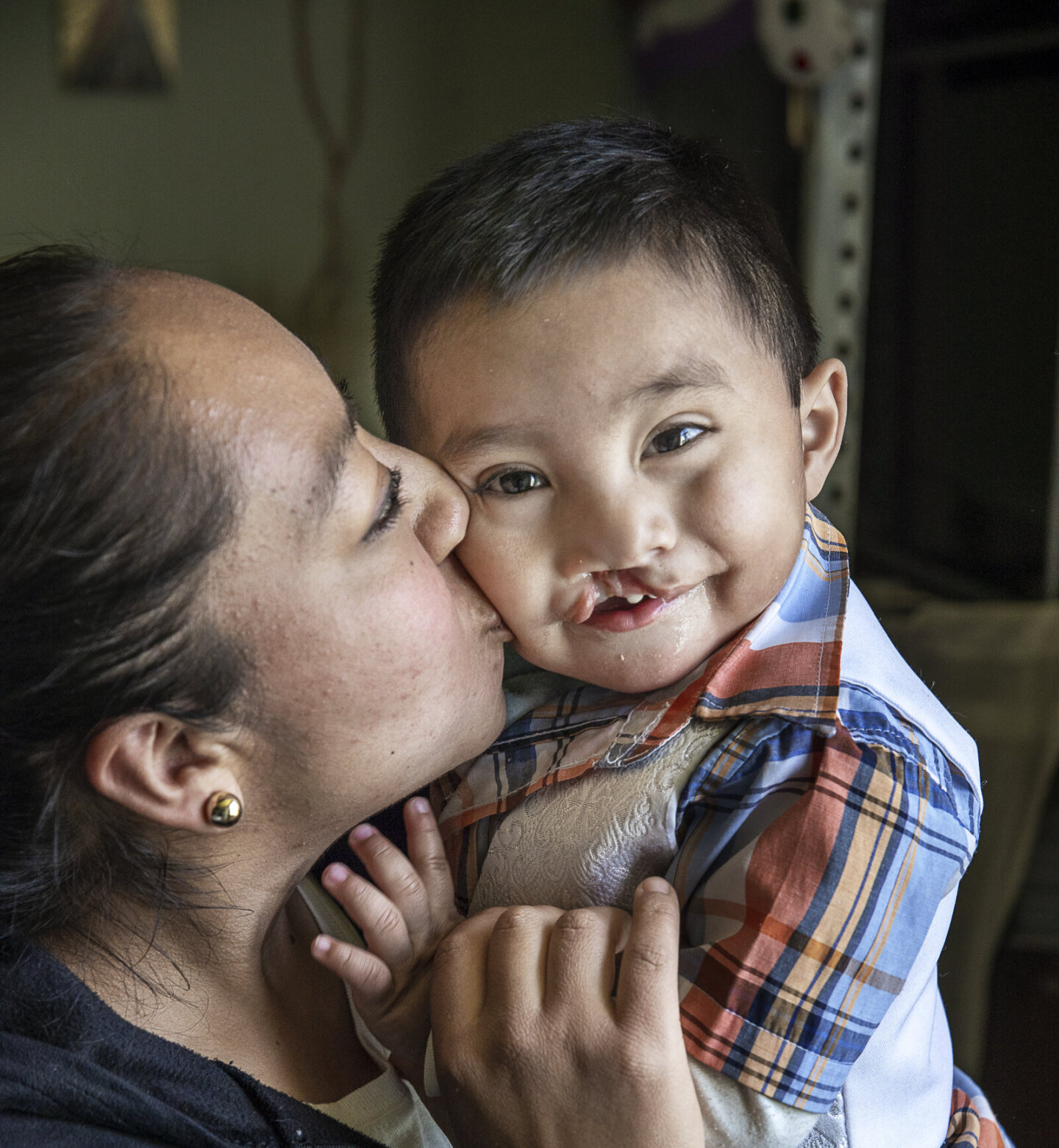 María gives her son, Sebastian, a kiss on the cheek.