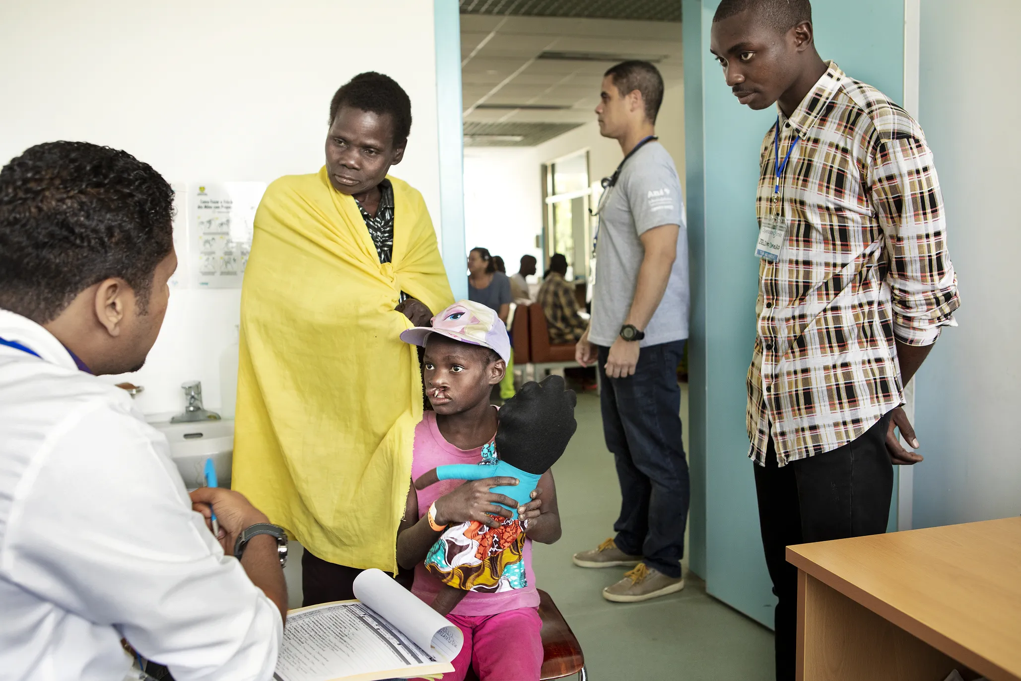 Bendita listens as an Operation Smile medical volunteer conducts his part of her daughter Noemia's comprehensive health evaluation.