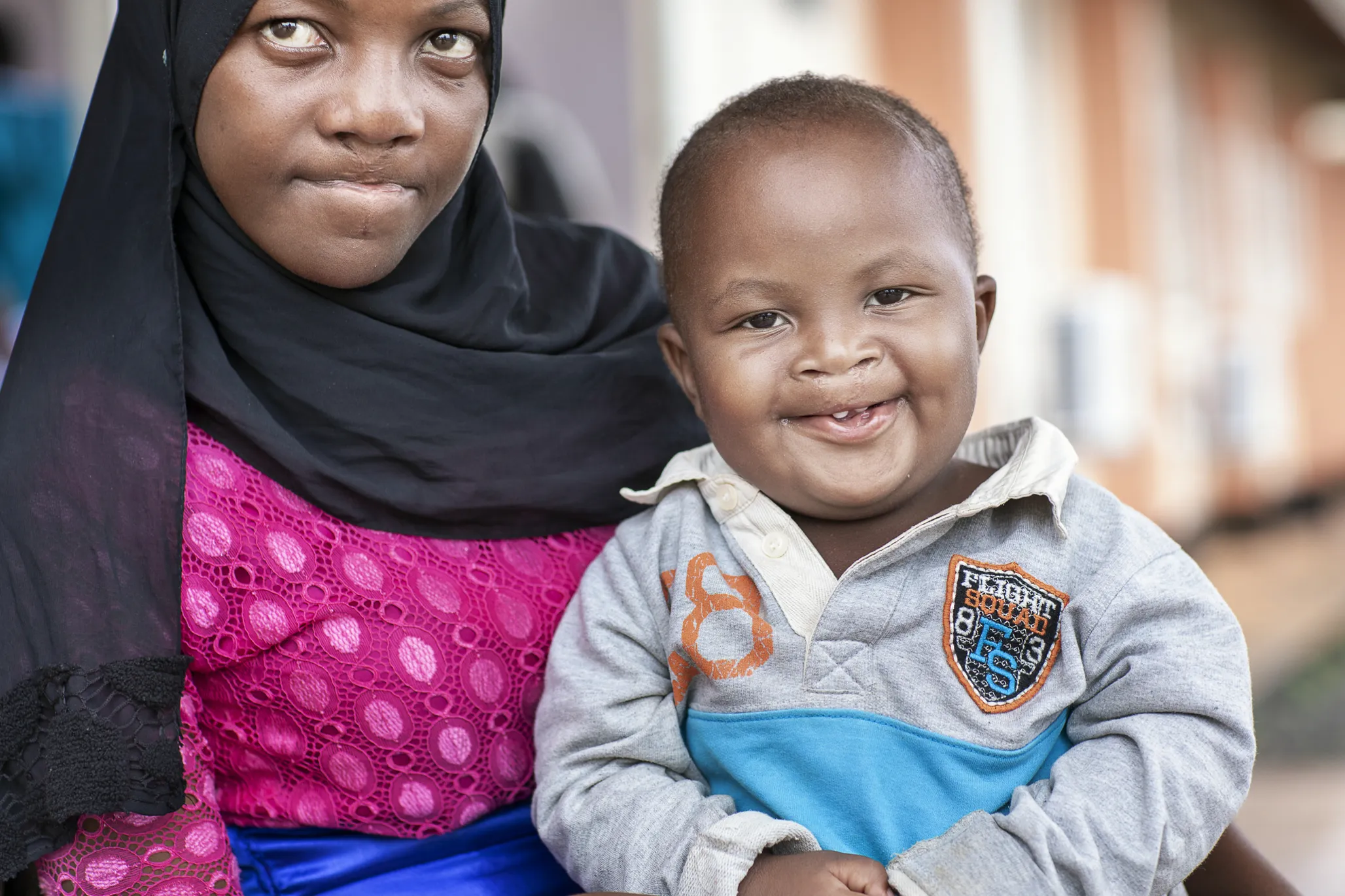 Ashraf smiles wide with his mother months after receiving surgery.