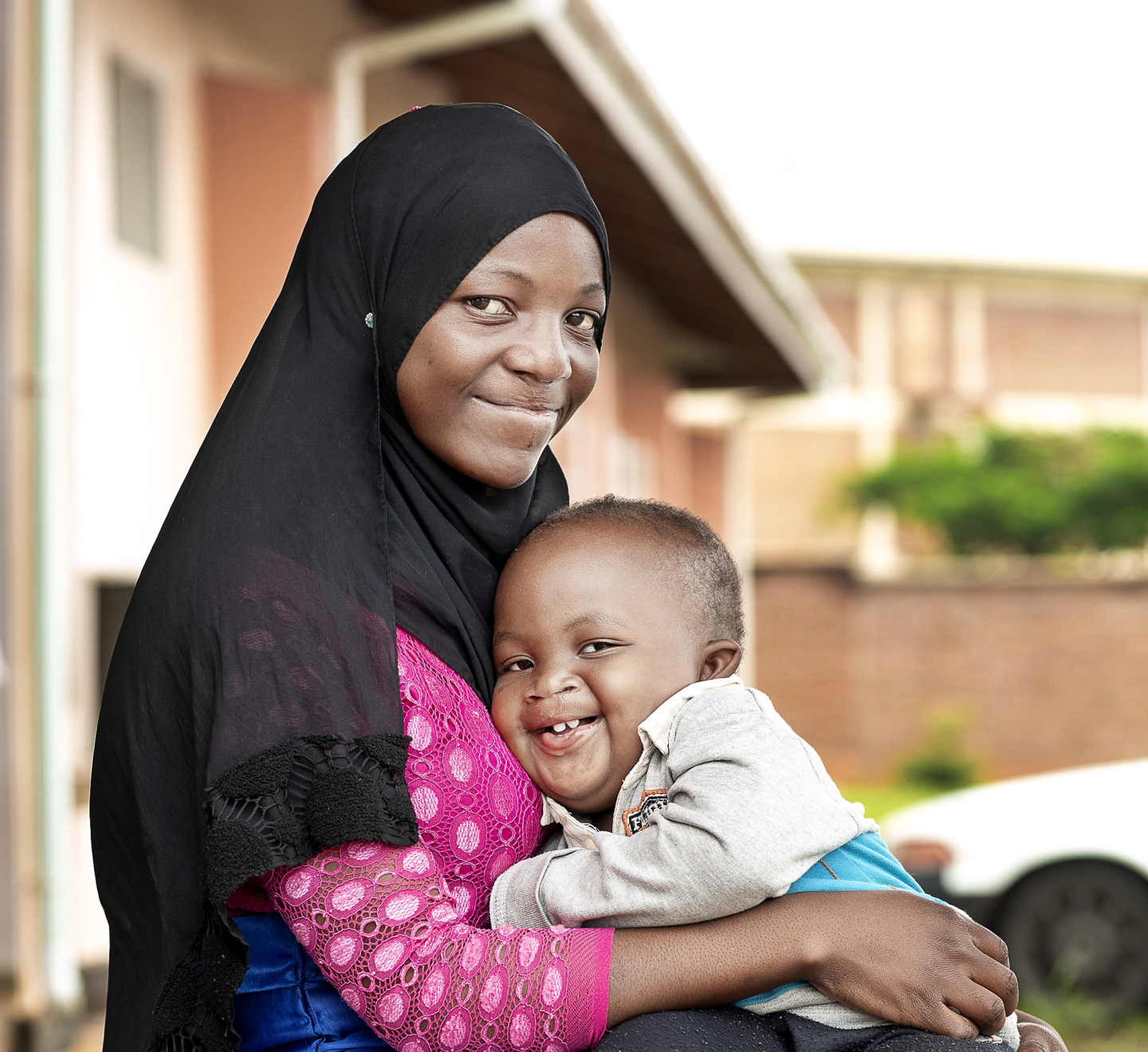 Ashraf smiles wide with his mother months after receiving surgery.