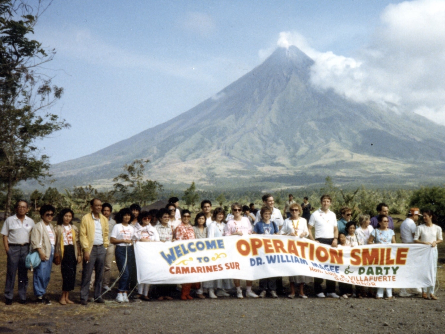 A welcome party holds a sign for Operation Smile in the early years of the organization's history.