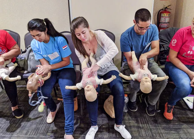 Paraguayan nurses Nilse, left, Fabiola and Luis practice saving a choking infant during a BLS course.